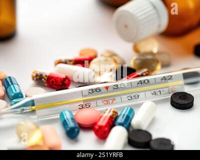 Abwechslungsreiche Medikamente und ein Thermometer in einer lebendigen Anzeige von Gesundheit und Wellness Stockfoto