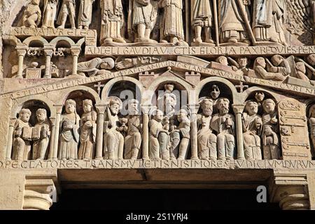 Die aufwendigen Skulpturen zeigen biblische Figuren und Motive entlang des Eingangs der Kirche in Conques. Stockfoto