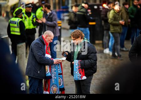 Mann, der Fußballschals an Fans im Stadtzentrum von Manchester verkauft Stockfoto