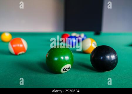 Eine Nahaufnahme eines Billardtisches, der einen acht Ball im Fokus hervorhebt. Zeigt das Spielsetup mit farbigen Kugeln, die auf das Spiel warten. Stockfoto