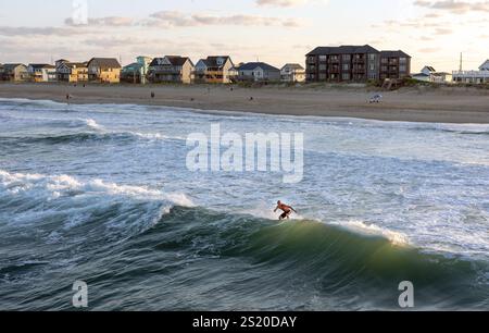 Ein Surfer, der auf einer Welle im Atlantik vor der Küste von Avon, North Carolina, reitet Stockfoto