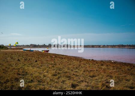 Lake Retba oder Lac Rose in der Nähe von Dakar im Senegal. Wunderschöner Blick auf den Strand von oben auf einen salzigen See, der tiefes Orange und Rosa des Wassers ausstrahlt. Stockfoto