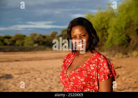 Junge, moderne Damara-Frau vor dem trockenen Omaruru-Fluss (Omaruru Rivier), TimBila Nature Reserve östlich von Omaruru, Erongo Region, Namibia Stockfoto