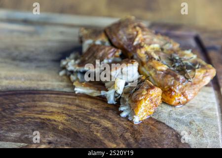 Knuspriger Rosmarin Schweinebauch auf einem schwarzen Walnussholz Schneidebrett Hintergrund. Stockfoto