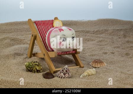Liegestuhl mit Euro-Währung am Sandstrand. Symbolfoto für Reise-, Urlaubs- und Urlaubskosten. Sparen im Urlaub Österreich Stockfoto