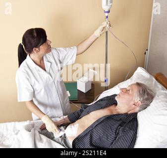 Eine Krankenschwester gibt einem Patienten eine Infusion Österreich Stockfoto