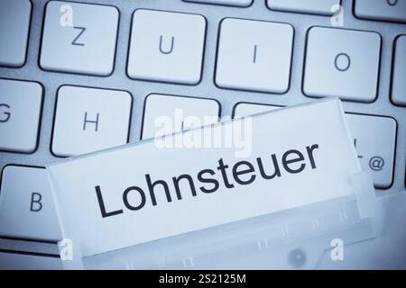 Ein Ordner für Akten in einer Hängedatei vor einer Computertastatur zum Thema Lohnsteuer Österreich Stockfoto