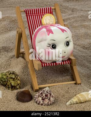 Liegestuhl mit Euro-Währung am Sandstrand. Symbolfoto für Reise-, Urlaubs- und Urlaubskosten. Sparen im Urlaub Österreich Stockfoto