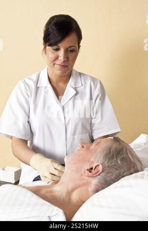 Eine Krankenschwester gibt einem Patienten eine Infusion Österreich Stockfoto