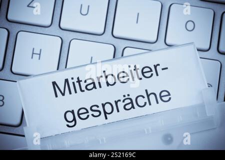 Ein Ordner für Akten in einer Hängeakte vor einer Computertastatur zum Thema Mitarbeitergutachten Österreich Stockfoto