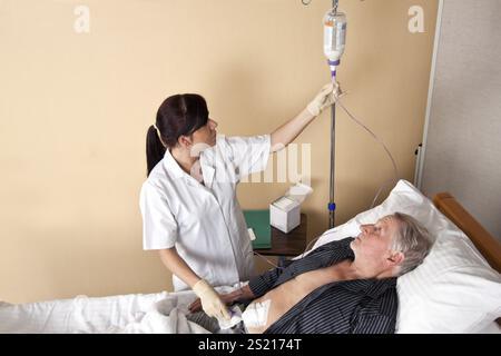 Eine Krankenschwester gibt einem Patienten eine Infusion Österreich Stockfoto