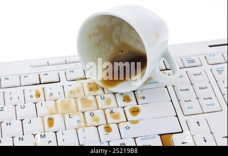 Kaffeetasse ist auf einer Computertastatur verschüttet. Schaden für die Versicherung. Österreich Stockfoto