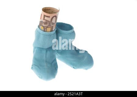 Blaue Kindersocken und Euro-Banknoten, symbolisiert durch Kindergeld Stockfoto