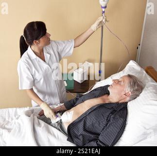 Eine Krankenschwester gibt einem Patienten eine Infusion Österreich Stockfoto