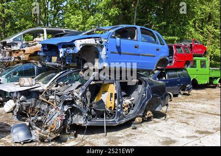 Viele Schrottwagen auf einem Schrottplatz warten darauf, zur Schrottpresse transportiert zu werden. Österreich Stockfoto