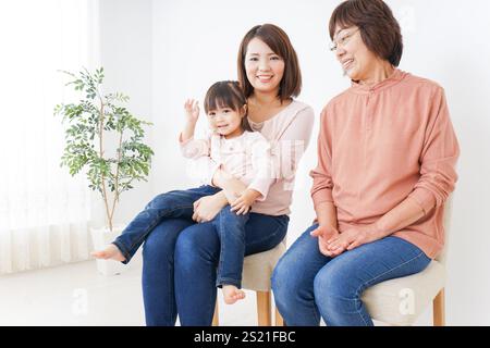 Drei Generationen sitzen auf Stühlen Stockfoto