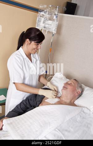 Eine Krankenschwester gibt einem Patienten eine Infusion Österreich Stockfoto