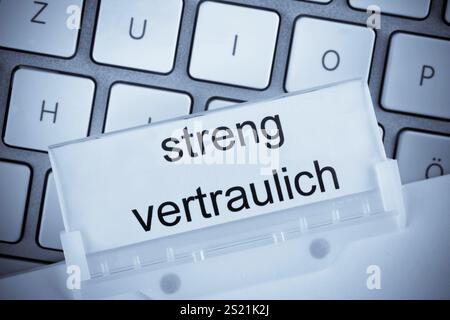 Der Ordner einer Hängeakte vor einer Computertastatur zum Thema streng vertrauliches Österreich Stockfoto