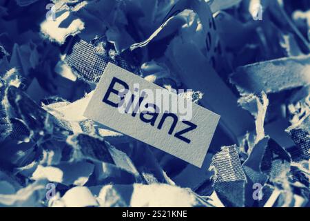 Papierschredder mit Schlüsselwort Bilanz, symbolischem Foto für Datenvernichtung, Ausgleich und wirtschaftliche Analyse Stockfoto