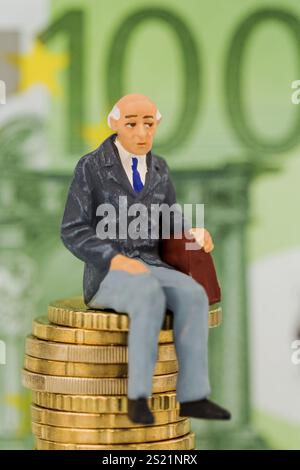 Rentner sitzt auf einem Haufen Geld, symbolisches Foto für Rente, Altersvorsorge, Alterssicherung Österreich Stockfoto