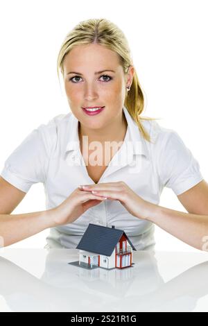 Eine Frau beschützt Ihr Haus und Ihr Zuhause. Gute Versicherungen und seriöse Finanzierungen sorgen für ein beruhigendes Gefühl Stockfoto