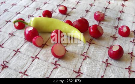 Rote Radieschen und gelbe Paprika auf dem Tisch Stockfoto