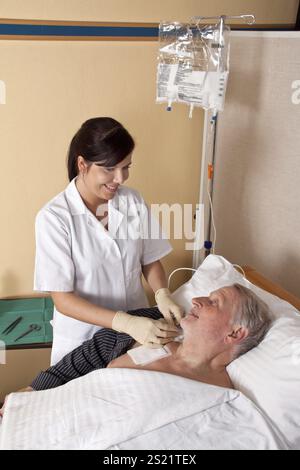 Eine Krankenschwester gibt einem Patienten eine Infusion Österreich Stockfoto