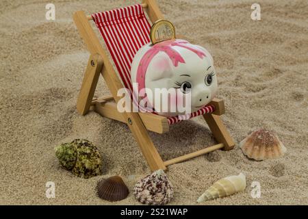 Liegestuhl mit Euro-Währung am Sandstrand. Symbolfoto für Reise-, Urlaubs- und Urlaubskosten. Sparen im Urlaub Österreich Stockfoto