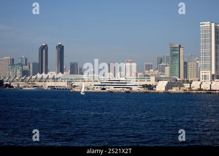 San Diego, Kalifornien, USA. Dezember 2024. Ein atemberaubender Blick auf die berühmte Skyline von San Diego, mit der modernen Architektur des San Diego Convention Center mit seinem unverwechselbaren segelähnlichen Dachdesign. Eine Luxusyacht liegt im Yachthafen an, während ein kleines Segelboot über das ruhige Wasser der Bucht gleitet. Die Hilton San Diego Bayfront und die Hochhäuser bilden eine beeindruckende Kulisse, die den lebhaften Küstencharme der Stadt unterstreicht. (Kreditbild: © Ian L. Sitren/ZUMA Press Wire) NUR REDAKTIONELLE VERWENDUNG! Nicht für kommerzielle ZWECKE! Stockfoto