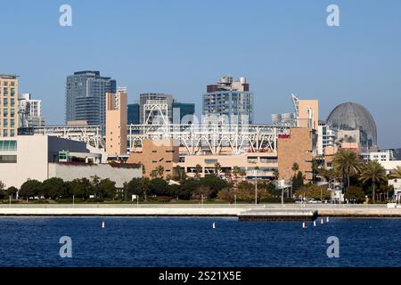 San Diego, Kalifornien, USA. Dezember 2024. Die Skyline von San Diego mit dem berühmten Petco Park Stadion, Heimstadion der San Diego Padres, wird im Zentrum hervorgehoben. Auf der rechten Seite ist die Kuppel der San Diego Central Library ein architektonisches Interesse an der Stadtlandschaft. Im Vordergrund des Ufers befindet sich eine friedliche Promenade, die von Bäumen gesäumt ist und einen Kontrast zu den belebten Hochhäusern der Stadt bildet. (Kreditbild: © Ian L. Sitren/ZUMA Press Wire) NUR REDAKTIONELLE VERWENDUNG! Nicht für kommerzielle ZWECKE! Stockfoto