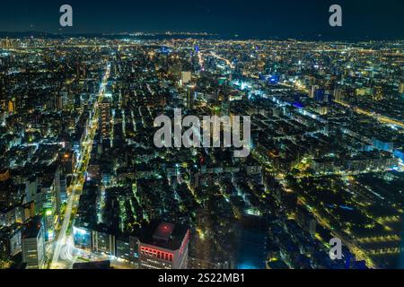 Blick auf die nächtliche Skyline von Taipei von der Aussichtsebene im Turm Taipei 101. Eine Stadtlandschaft voller beleuchteter Straßen und Gebäude Stockfoto