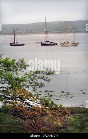 Traditionelle Segelboote auf schwingenden Anlegestellen in der Pinmühle am Fluss orwell suffolk england Stockfoto