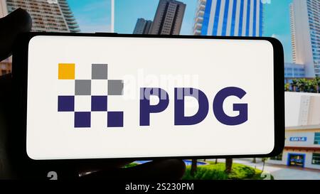 In dieser Abbildung hält eine Person ein Handy mit dem Logo des brasilianischen Immobilienunternehmens PDG Realty SA auf dem Bildschirm vor der Website. (Foto von Timon Schneider / SOPA Images/SIPA USA) *** ausschließlich für redaktionelle Nachrichtenzwecke *** Stockfoto