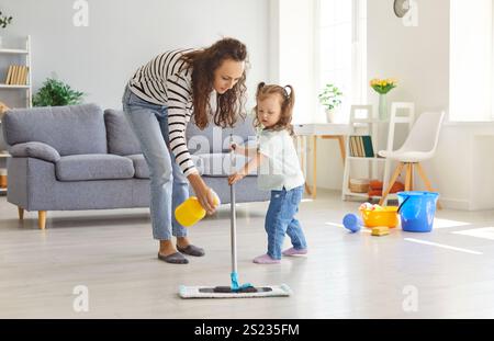 Gemeinsame Familie Mutter und Tochter Reinigungsraum mit Mopp und Pulverisierer, zusammen Hausarbeit. Stockfoto