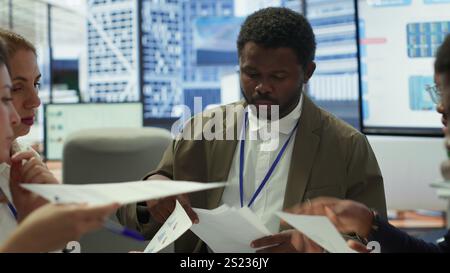 Der Enterprise Manager arbeitet mit seinen Mitarbeitern an der Erstellung einer Geschäftsstrategie und der Festlegung von Zielen, untersucht die Marktdynamik und Verkaufszahlen. Das Team des Unternehmens nimmt an einer Entwicklungsbesprechung Teil. Kamera A.. Stockfoto