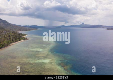 Aus der Vogelperspektive auf die Lagune von Mayotte mit sichtbaren Korallenriffflächen und der kleinen Insel Sada im Vordergrund. Die Aufnahme erfasst den Kontrast zwischen dem Stockfoto