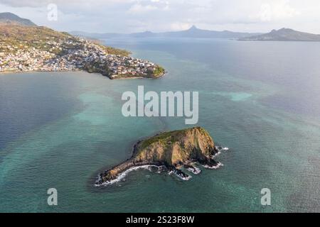 Aus der Vogelperspektive auf die Lagune von Mayotte mit sichtbaren Korallenriffflächen und der kleinen Insel Sada im Vordergrund. Die Aufnahme erfasst den Kontrast zwischen dem Stockfoto