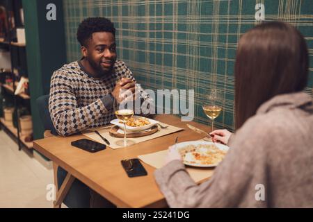 Zwei Freunde essen im Restaurant. Sie sitzen, reden und genießen die gemeinsame Zeit. Stockfoto