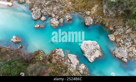 Ein türkisfarbener Fluss schlängelt sich durch felsiges Gelände, umgeben von üppiger Wildnis in Albanien. Stockfoto