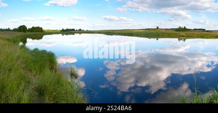 Sommerpanorama mit Blick auf den rauschigen See mit Wolkenspiegeln. Fünf Aufnahmen zusammengesetztes Bild. Stockfoto