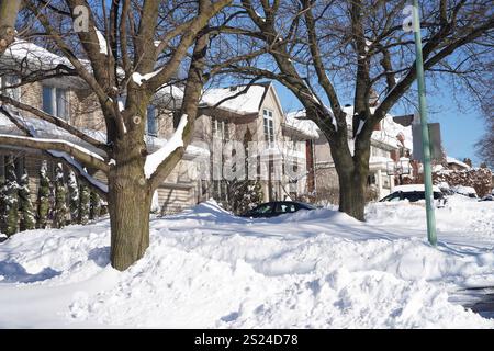 Vorstadtwohnstraße an einem sonnigen Morgen nach einem großen Schneesturm Stockfoto