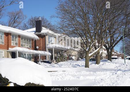 Vorstadtwohnstraße an einem sonnigen Morgen nach einem großen Schneesturm Stockfoto