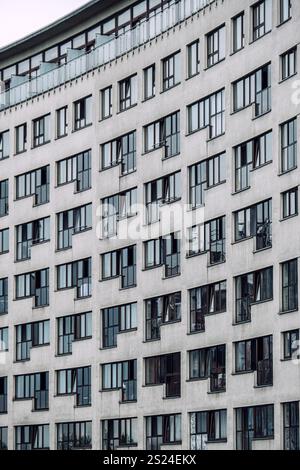 Nahaufnahme eines Wohngebäudes mit rasterartigen Fenstern und zeitgenössischer minimalistischer Architektur. Stockfoto
