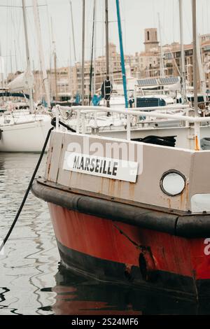 Aus nächster Nähe ein Boot im Hafen von Marseille, Frankreich, mit dem Namensschild „MARSEILLE“. Der Hintergrund zeigt den Yachthafen. Stockfoto
