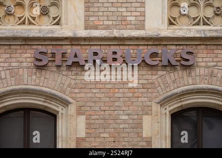 Prag, Tschechische Republik. 4. Oktober 2024 – Starbucks Logo auf einer historischen Backsteinmauer in der Prager Burg Stockfoto