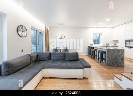 Modernes, offenes Wohnzimmer und Küche mit modernen Möbeln, einer Treppe und elegantem Dekor in sanften neutralen Farben für einen stilvollen und stilvollen Stil Stockfoto