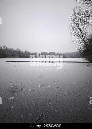 Prag, Tschechische republik - 27. Dezember 2024: Heitere Winterszene, die einen gefrorenen Seeteich mit weit entfernten Gebäuden in prag, tschechien, auf einem Clo einfängt Stockfoto