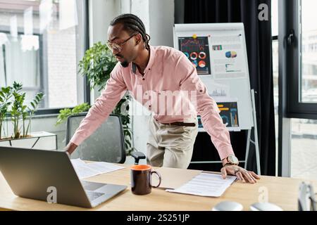 Ein junger afroamerikanischer Mann arbeitet ferngesteuert in einem stilvollen Büro, um das Leben digitaler Nomaden zu genießen. Stockfoto
