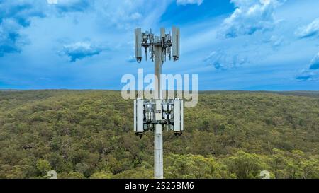 Drohnenfoto des oberen Teils eines Telekommunikationsturms, der mit Antennen und Übertragungseinrichtungen ausgestattet ist. Stockfoto