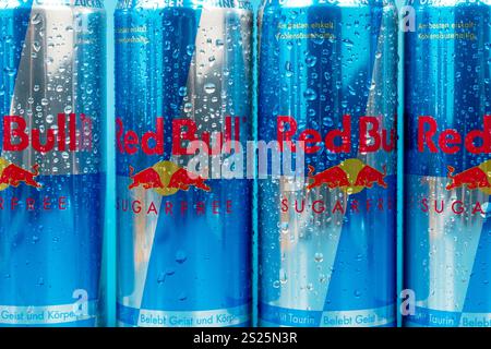 Vier Dosen Red Bull Sugarfree Limonade stehen nebeneinander. Die Dosen sind feucht durch Kondensation, und das Soda im Inneren ist spritzig und erfrischend. Stockfoto
